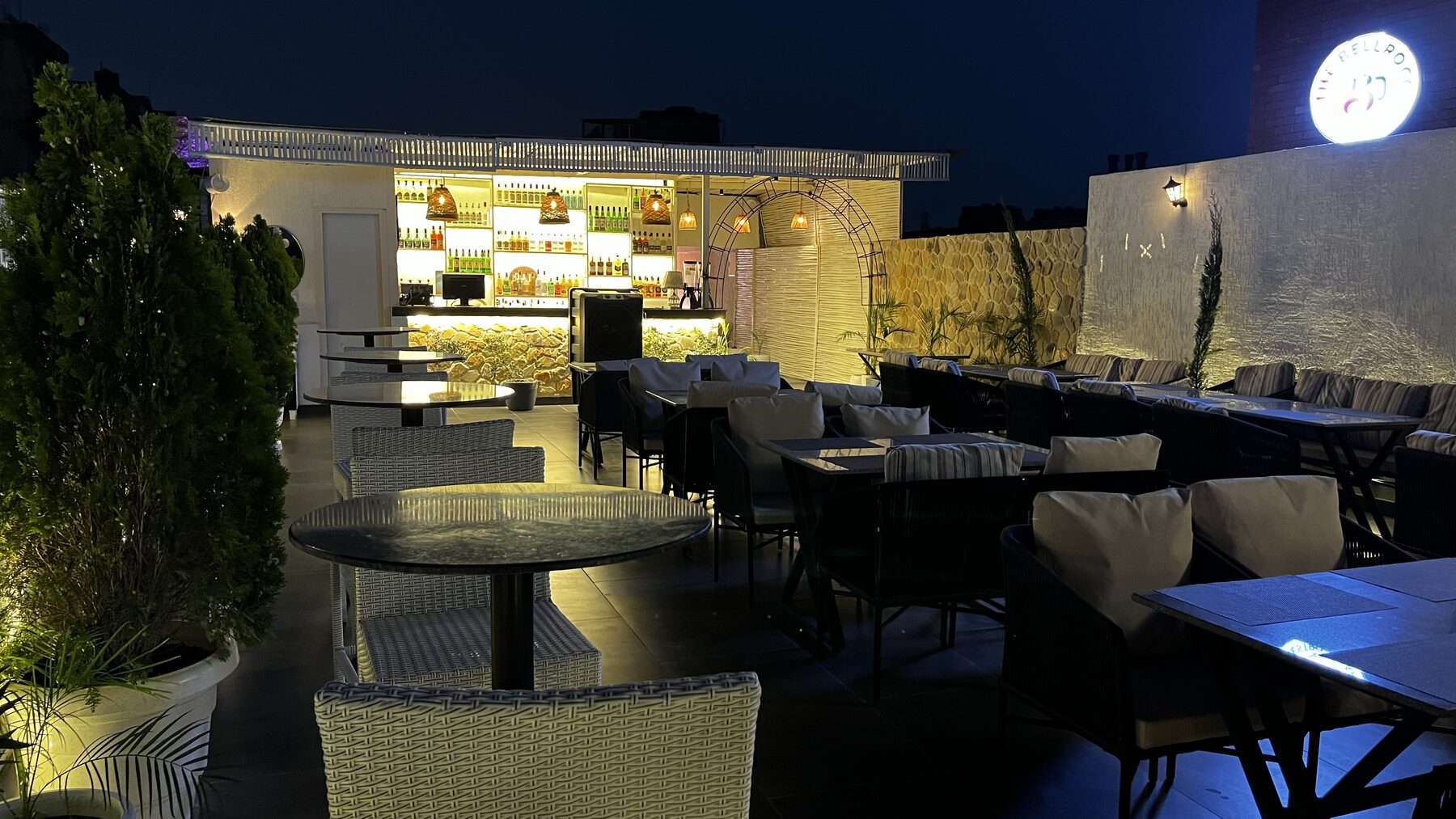 Rooftop lounge seating facing the illuminated open-air bar at The Bellrocc, Patiala
