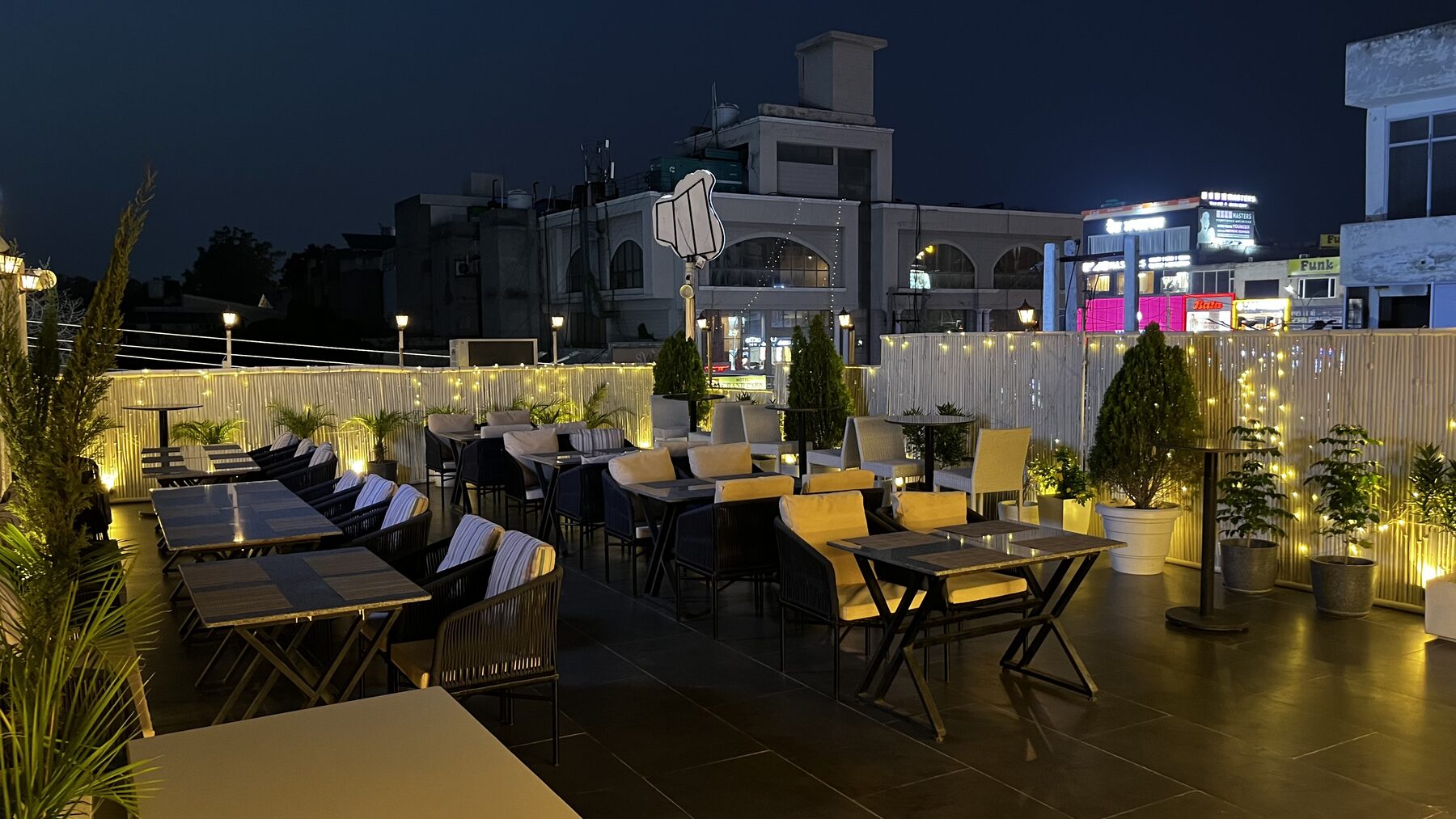 Open-air rooftop terrace seating at The Bellrocc, Patiala, lit with warm fairy lights at night